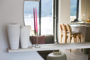 a counter with two white vases and two red candles at Forest View Hideaway in Braşov