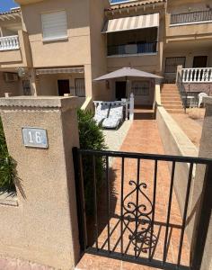 an apartment building with an address sign on a fence at Tranquil Self Catering Golf Course Apartment in Alicante