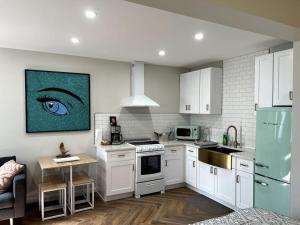 a kitchen with white cabinets and a blue eye on the wall at Downtown Groovy Studio in Orlando