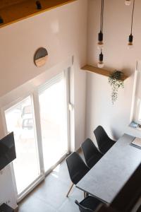 een eetkamer met een tafel en stoelen en een raam bij Apartment house GAIA in Gajac