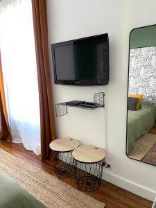 Cette chambre dispose de deux tabourets et d'une télévision murale. dans l'établissement Havre de paix moderne, fibre,RER B direction Paris, à Fontenay-aux-Roses