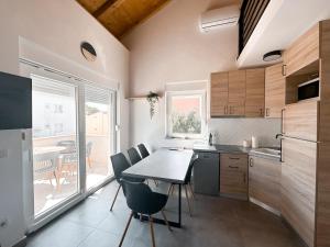 een keuken met een tafel en stoelen en een raam bij Apartment house GAIA in Gajac