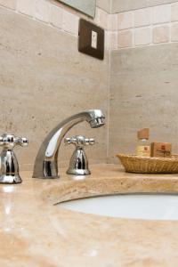 a bathroom sink with two faucets on a counter at Hotel Suiza Peruana in Huaraz