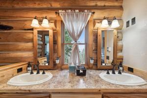 two sinks in a log cabin bathroom with two mirrors at Sweathouse Creek Lodge in Victor +40 photos