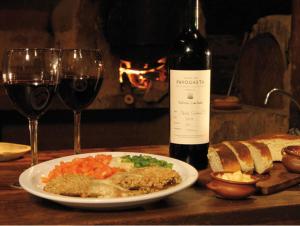 a table with a plate of food and a bottle of wine at Sala de Payogasta in Payogasta