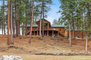 a log home in the woods with trees at Sweathouse Creek Lodge in Victor