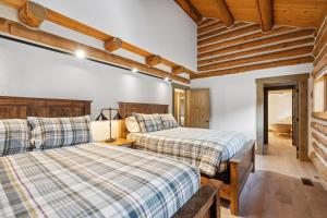 two beds in a room with wooden ceilings at Mountain Escape Lodge in Victor