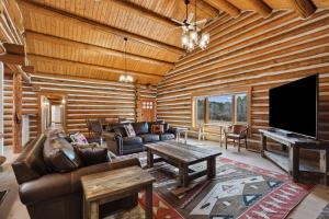 a living room with a couch and a flat screen tv at Mountain Escape Lodge in Victor
