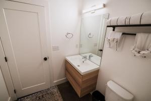 a white bathroom with a sink and a mirror at Modern Missoula Bungalow in Missoula +20 photos