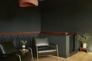 a waiting room with two chairs and a green wall at Yarn - Milo Deluxe King Suite in Ballycastle