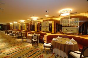 a restaurant with tables and chairs in a room at Royal Palace Hotel Haining in Haining