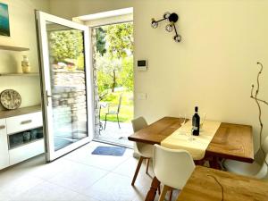 a dining room with a wooden table and a sliding glass door at Rosa del lago in Gravedona