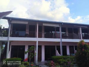 an apartment building with a large balcony with a lot of windows at Bernard's Guest Houses in Tuktuk Siadong