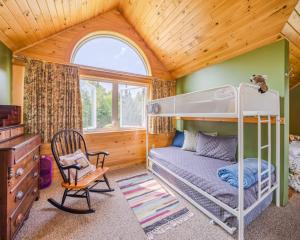Un dormitorio con una litera y una silla. en Dragonwood Bunk House, en Abbot Village