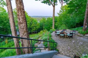 eine Terrasse mit einem Tisch, Stühlen und Bäumen in der Unterkunft Dragonwood Main House in Abbot Village