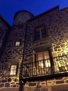 a large stone building with a balcony at La Tour du Marché in Allanche