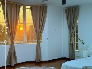 a bedroom with a window with a view of the sunset at NEW Event House OUG KL Spacious 18pax in Kuala Lumpur +34 photos