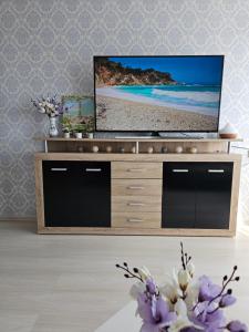 a living room with a tv on a entertainment center at JJ apartment in Jelgava