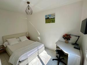 a bedroom with a bed and a desk with a television at Idéal pour visiter Paris in Saint-Mandé