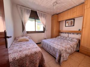 a bedroom with two beds and a window at Costa Cunit in Cunit