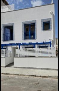a white building with blue trim and windows at Panhouse Rooms & Suite in Palermo