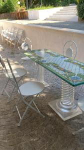 a glass table and chairs on a patio at Casa Veientana in Labaro +25 photos