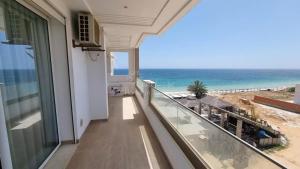 a balcony with a view of the beach at Location saisonniere Appartement Chatt Meriem in Kasnadar