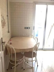 ein Tisch und Stühle in einem Zimmer mit Fenster in der Unterkunft location saisonniere S2 a corniche in Kasnadar