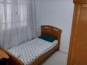 ein kleines Bett in einem Zimmer mit Vorhang in der Unterkunft location saisonniere S2 a corniche in Kasnadar