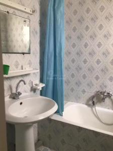 ein Badezimmer mit Waschbecken und Duschvorhang in der Unterkunft location saisonniere S2 a corniche in Kasnadar