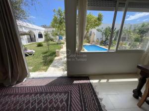 a room with a window and a view of a pool at location Maison d hotes a Chott Meriem in Kasnadar