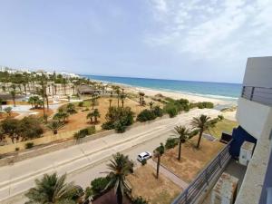 a view of the beach from the balcony of a building at Super appartement a louer zone touristique Sousse. in Kasnadar
