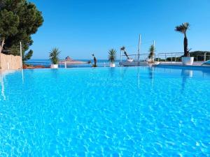 a swimming pool with blue water in a resort at Villa Prestige Rafraf in Bin Rhilouf