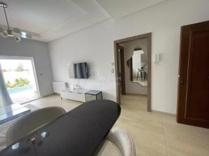 a living room with a table and a tv at location saisonniere s1 avec piscine privee Palm Lake in Monastir