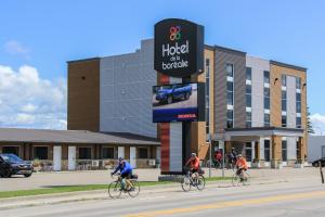 a group of people riding bikes down a street at Hotel De La Borealie in Saint-Félicien
