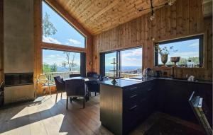a kitchen and dining room with large windows at Cozy Home In Rauland With Sauna in Rauland