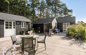 a patio with a table and chairs and a shed at 5 Bedroom Awesome Home In Slagelse in Slagelse