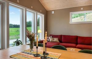 a living room with a red couch and a table at 2 Bedroom Amazing Home In Säffle in Säffle