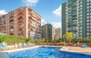 a swimming pool in front of some tall buildings at Nice Apartment In Fuengirola With Wifi in Fuengirola +9 photos