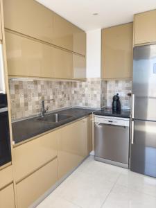 a kitchen with a sink and a refrigerator at Riamar House - Faro City Center in Faro