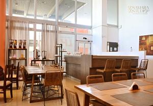 a restaurant with wooden tables and chairs and a bar at Lujan Homes Apart Hotel in Luján