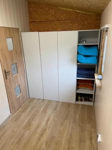 a room with white cabinets and a wooden floor at Lasek Siemiany in Siemiany +1 photo