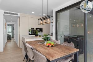 a kitchen and dining room with a wooden table and chairs at Penthouse Santa Rosalia in Las Casicas +27 photos