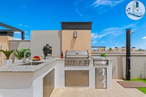 a outdoor kitchen with a grill and a sink at Penthouse Santa Rosalia in Las Casicas