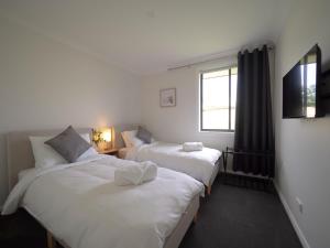 a room with two beds and a window at Little Manhattan - Dubbo in Dubbo