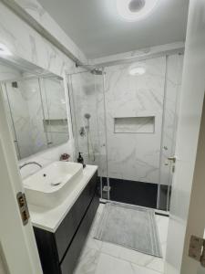 a white bathroom with a sink and a shower at Riamar House - Faro City Center in Faro +10 photos
