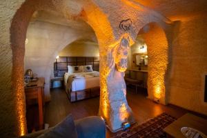 a bedroom with a bed in a stone room at Urgup Evi Cave Hotel in Ürgüp