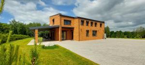 a brick building with a large driveway in front at Marių įlanka in Marijampolė