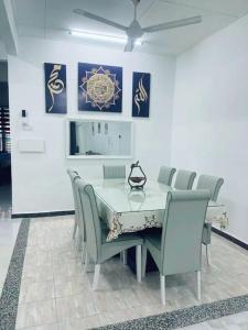 Kota BharuFZ's Paduka Homestay Kubang Kerian的餐厅里有一张桌子和几把椅子