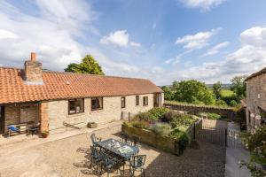 einen Blick über ein Cottage mit einem Tisch und Stühlen in der Unterkunft Valley View Farm Holiday Cottages in Helmsley